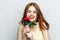 cheerful red-haired woman holding flower rose reborn charm model isolated background