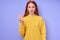 cheerful redhead woman in yellow stylish sweater demonstrating letter N