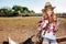 Cheerful redhead young woman cowgirl using cell phone in village