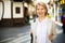 Cheerful retiree woman having a walk in city