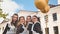 Cheerful Russian girls graduating with orange balloons on the last school day.