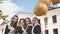 Cheerful Russian girls graduating with orange balloons on the last school day.