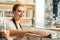 Cheerful saleswoman cleaning glass case