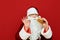 Cheerful Santa Claus stands on a red background with a burger in his hand, shows his finger the OK sign, looks into the camera and