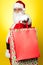 Cheerful Santa holding vibrant colored bags