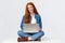 Cheerful sassy redhead female student, college girl in glasses, sitting on crossed legs with laptop, working freelance