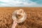 Cheerful satisfied farmer holding straw hat outdoors