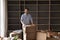 Cheerful satisfied property buyer man posing at stack of boxes