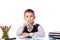 Cheerful satisfied thoughtful smiling pupil sitting at the desk on the white background