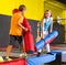 Cheerful school-age boy and teen girl friends having fun on inflatable gladiator fight arena in indoor amusement center