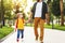 Cheerful schoolboy walking to school with father