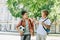 Cheerful schoolboys with backpacks talking while walking in green park