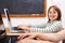 Cheerful schoolgirl with laptop