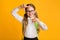 Cheerful Schoolgirl Looking At Camera Through Fingers Frame, Studio Shot