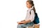 cheerful schoolkid sitting on books isolated on white.