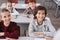 cheerful schoolkids smiling while sitting at