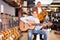 Cheerful seller showing guitar to boy client