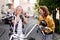 A cheerful senior couple travellers in love with motorbike in town.