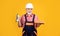 cheerful senior man bricklayer in helmet on yellow background