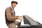 Cheerful senior man playing a digital keyboard piano