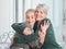 Cheerful senior mother hugging her adult daughter. Loving caucasian mom giving her daughter a hug while sitting on a