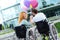 Cheerful senior wheelchaired couple holding balloons