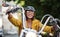 Cheerful senior woman traveller with motorbike in town.