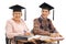 Cheerful seniors with graduation hats sitting in school chairs