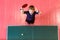 Cheerful seven-year-old child enjoys winning table tennis, top view. Green table tennis table