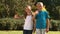 Cheerful siblings waving together in their garden