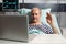 Cheerful sick senior man waving at camera during video conference