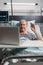 Cheerful sick senior man waving at camera during video conference