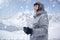 Cheerful skier looking afar before starting to skiing. Happy man enjoying holiday in winter season. Smiling mountaineer skier in w