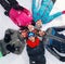 Cheerful skiers lying on snow and having fun top view