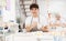 Cheerful skilled young artist painting ceramic cup in pottery workshop