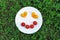 Cheerful smiley from tomato on a round white plate.