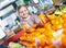 Cheerful smiling little girl purchasing sweet mandarines