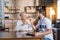 Cheerful smiling pensioner getting pills from a young social worker