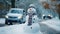 Cheerful smiling snowman wearing scarf and hat, at the sidewalk of a street in the city on a cold winter day. Generative AI