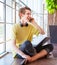 Cheerful smiling teenage boy talking by phone