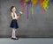 Cheerful smiling young little girl the child draws on the background wall colored paints making a creative repairs.