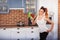 Cheerful sports woman holding glass dish with various vegetables