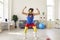 Cheerful sportsman in multicolored sport clothes feeling powerful during workout at home
