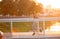 Cheerful sporty jogger running on bridge in morning