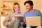 Cheerful Spouses Using Laptop And Digital Tablet Websurfing At Home