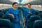 Cheerful stewardesses standing in aircraft passenger salon