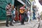 Cheerful street musicians playing on a street outdoors and people watching on a terrace in Cuba