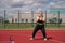 Cheerful strong self-confident plump woman does sports on an outdoor playground