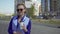 Cheerful stylish businesswoman drinking coffee outside on urban background