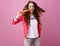 Cheerful stylish woman on pink background eating carrot